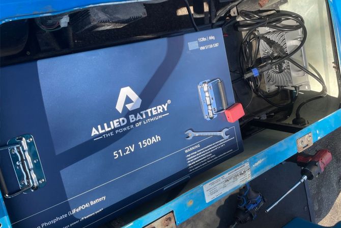 Blue box containing a large Allied Battery, 51.2V 150Ah, with a wrench and screwdriver.