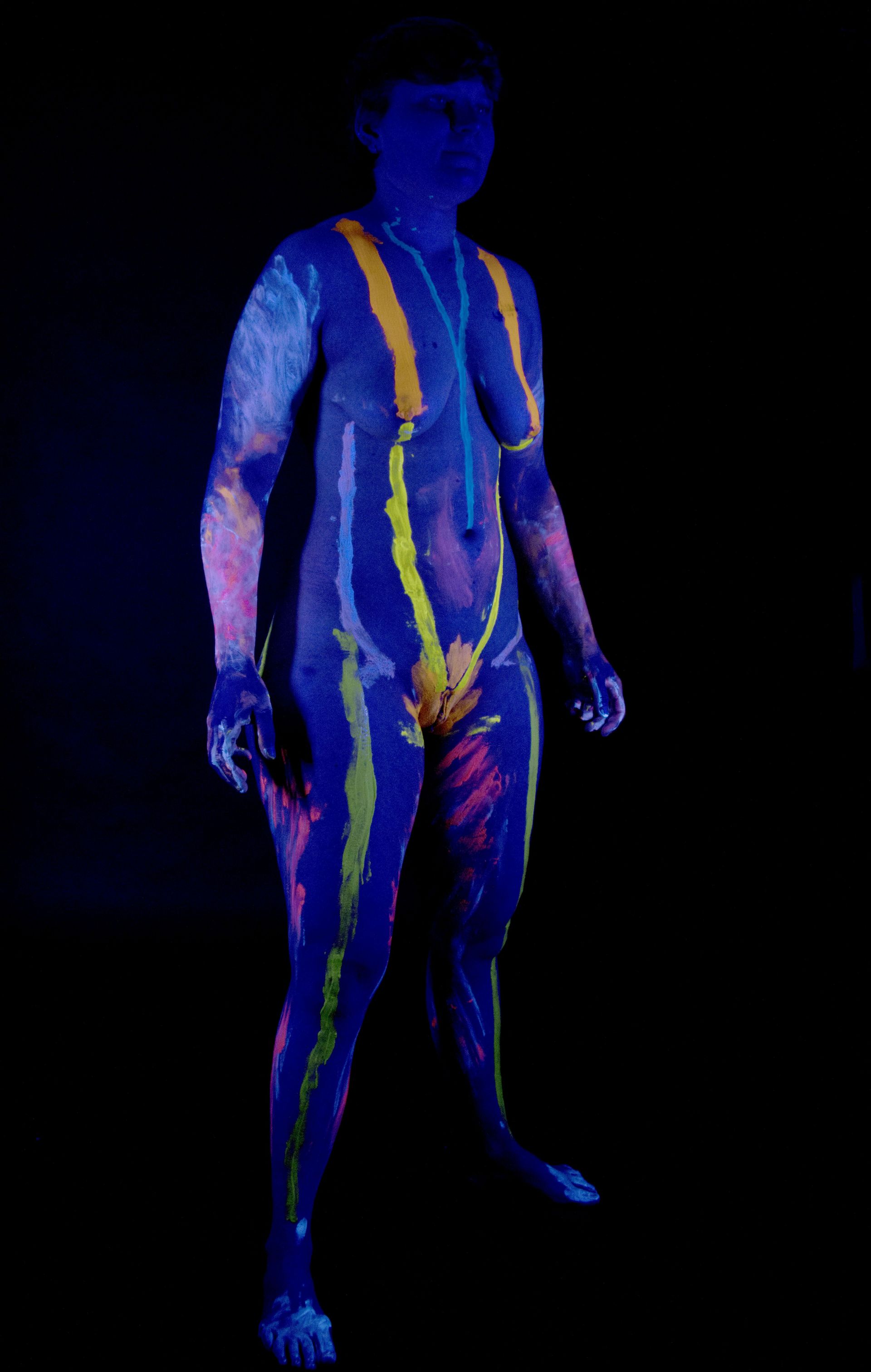Een thermische scan van het hele lichaam van een staande persoon op een zwarte achtergrond, met een blauw lichaam en gele warmtegebieden.