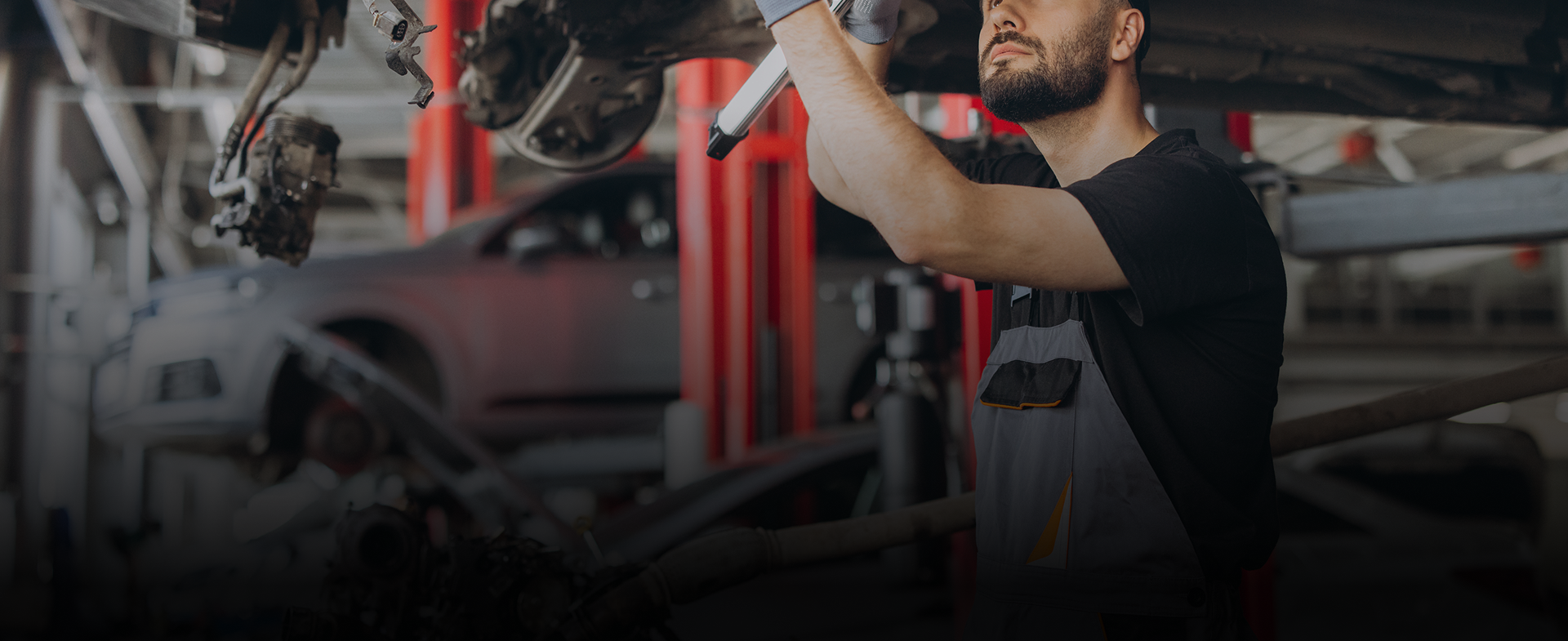 Technician working under hood of vehicle | Hanlon's Tire Service