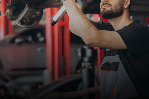 Technician working under hood of vehicle | Hanlon's Tire Service