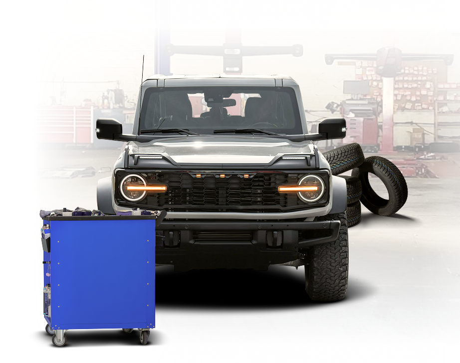 Gray vehicle inside of garage with blue toolbox | Hanlon's Tire Service