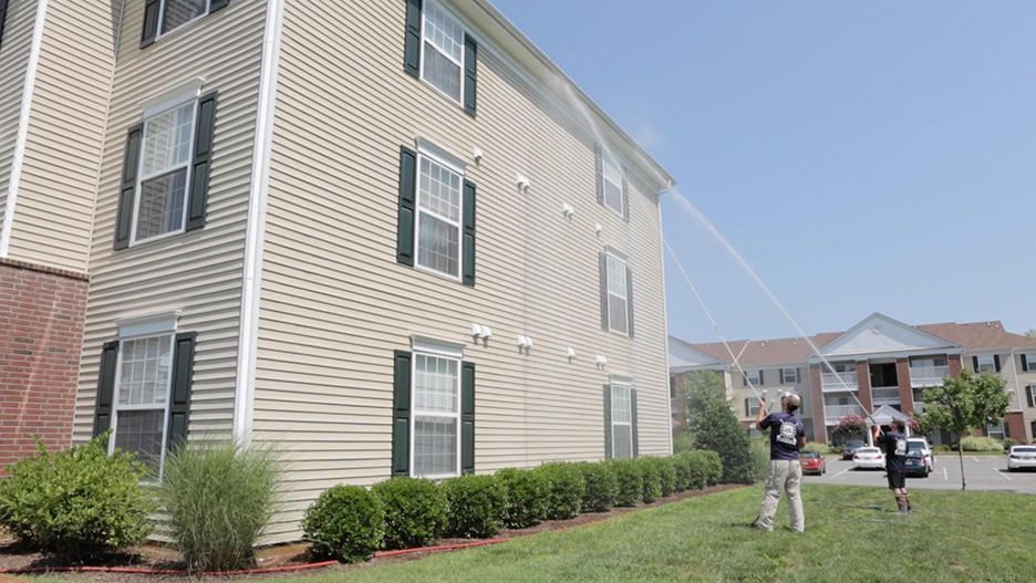 Pressure washing siding of house