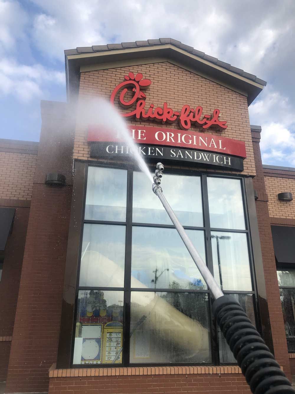 Pressure washing siding of house