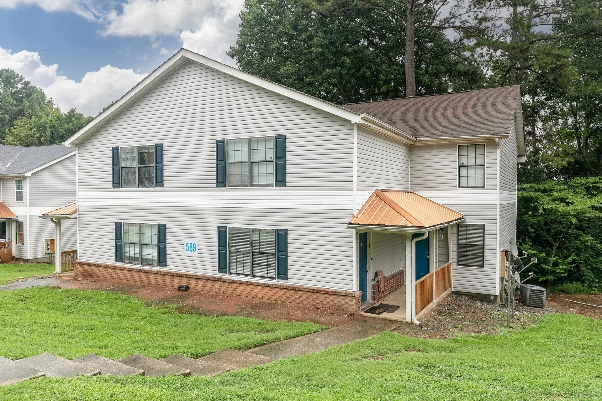 Riverdale, GA Pet-Friendly Apartments - Briar Hill 563 - Property With A Big Front Yard, Manicured Grass, And Trees.