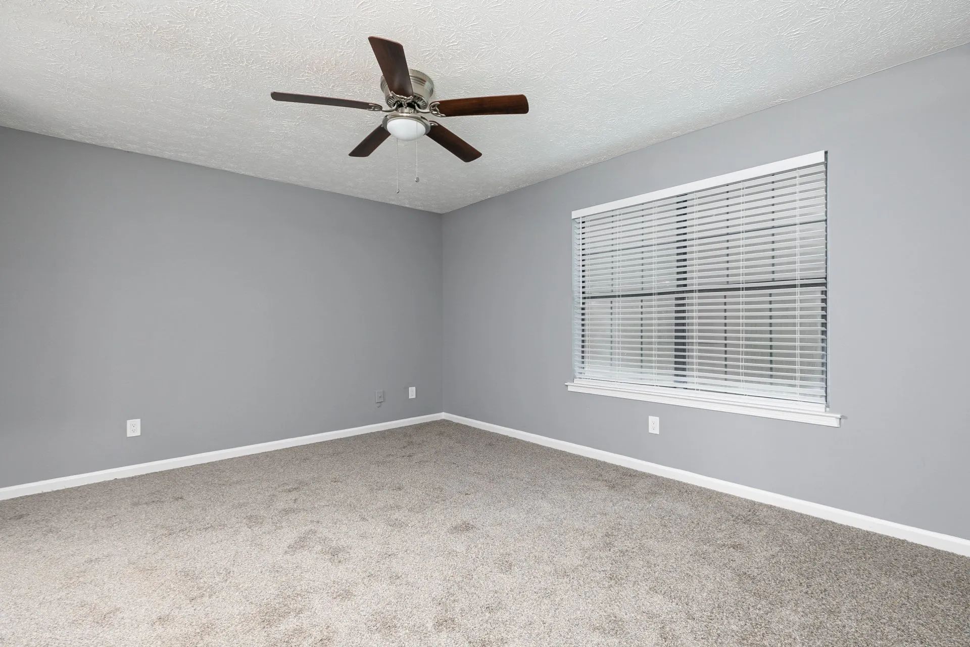 One-Bedroom Apartments in Riverdale, GA - Briar Hill 563 - Unfurnished Bedroom with Carpeted Floor, Grey Walls, Ceiling Fan, and Window with Blinds