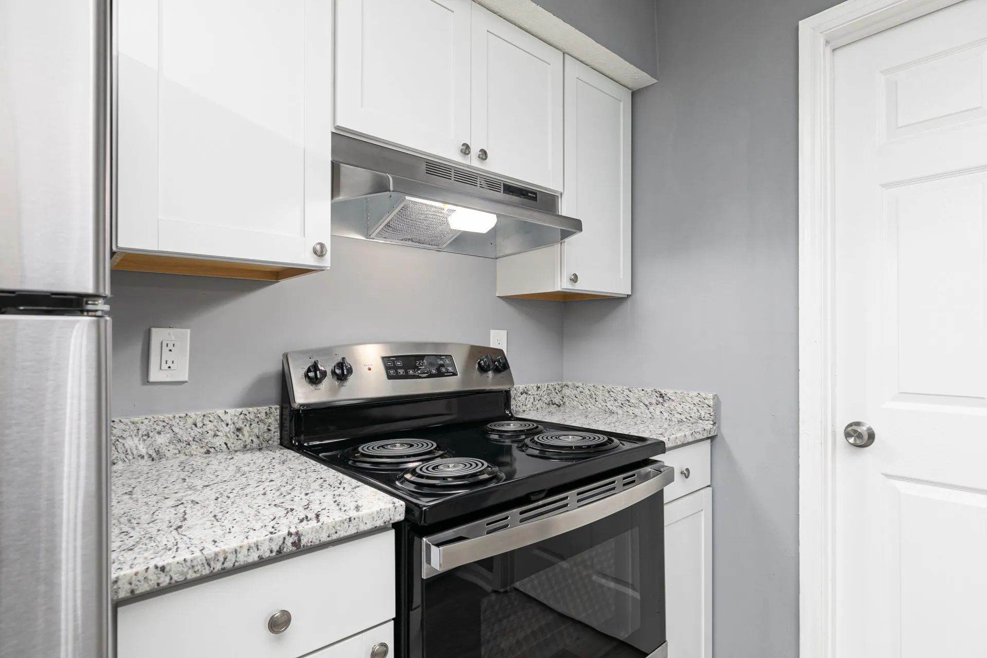 Apartments for Rent in Riverdale, GA - Briar Hill 563 - Modern Kitchen with
Granite Countertops, Grey Walls,
Stainless Steel Appliances, and White Cabinetry