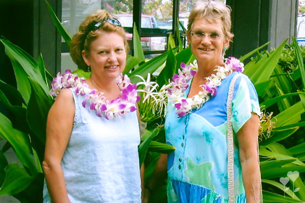 two women wearing lei are standing next to each other