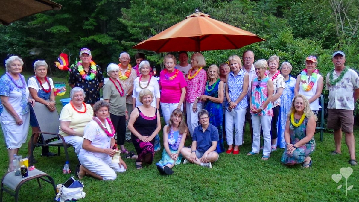 a group of people posing for a picture under an orange umbrella