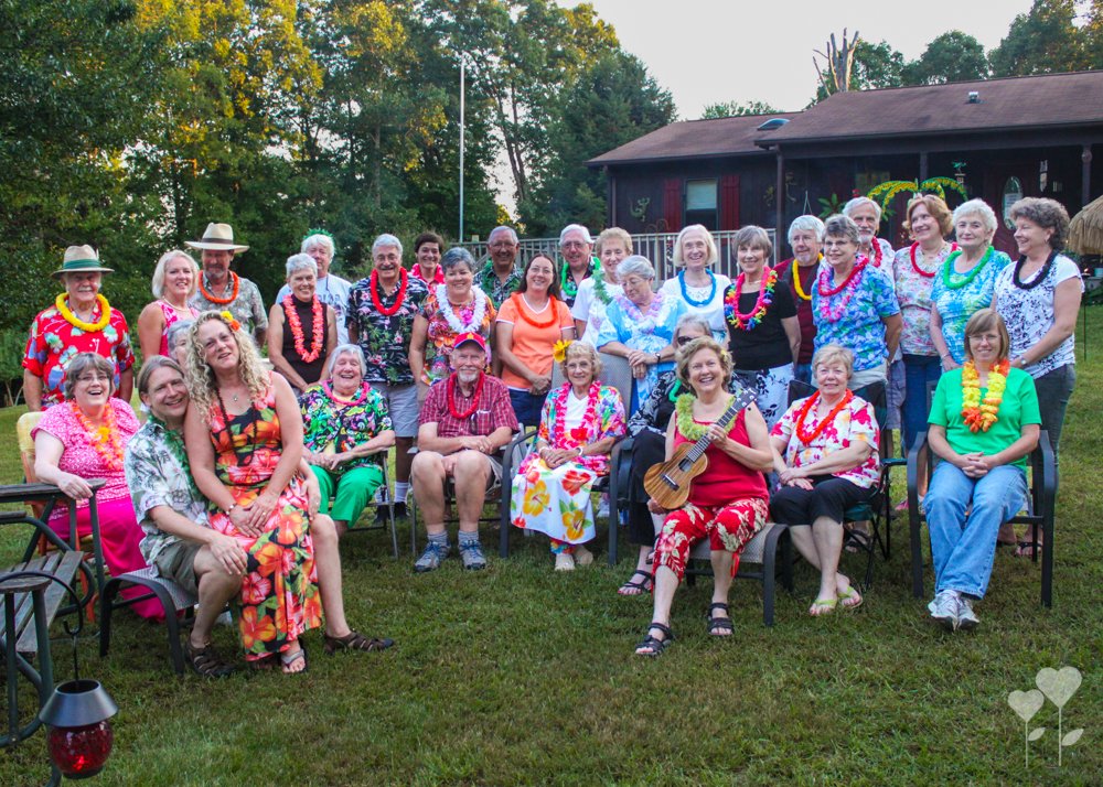 a group of people are posing for a picture in front of a house