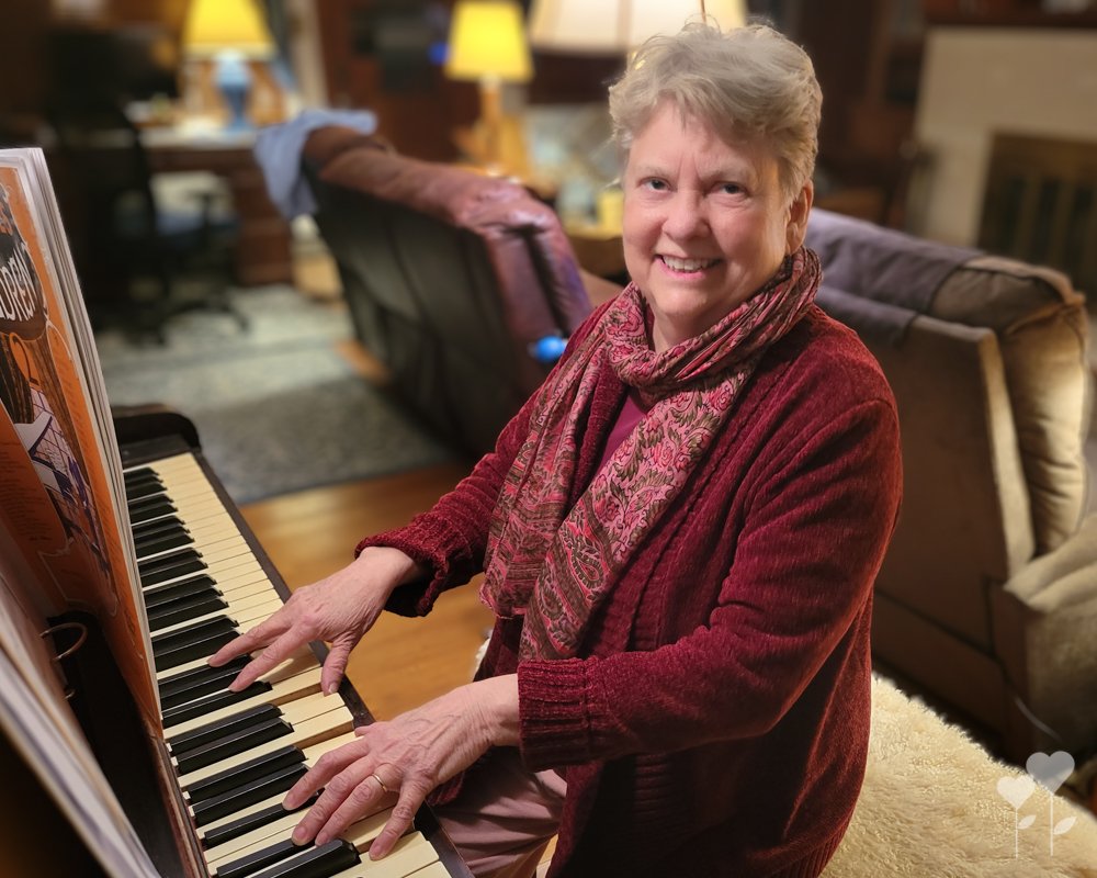 an woman playing a piano with a book behind her that says ' i love you '