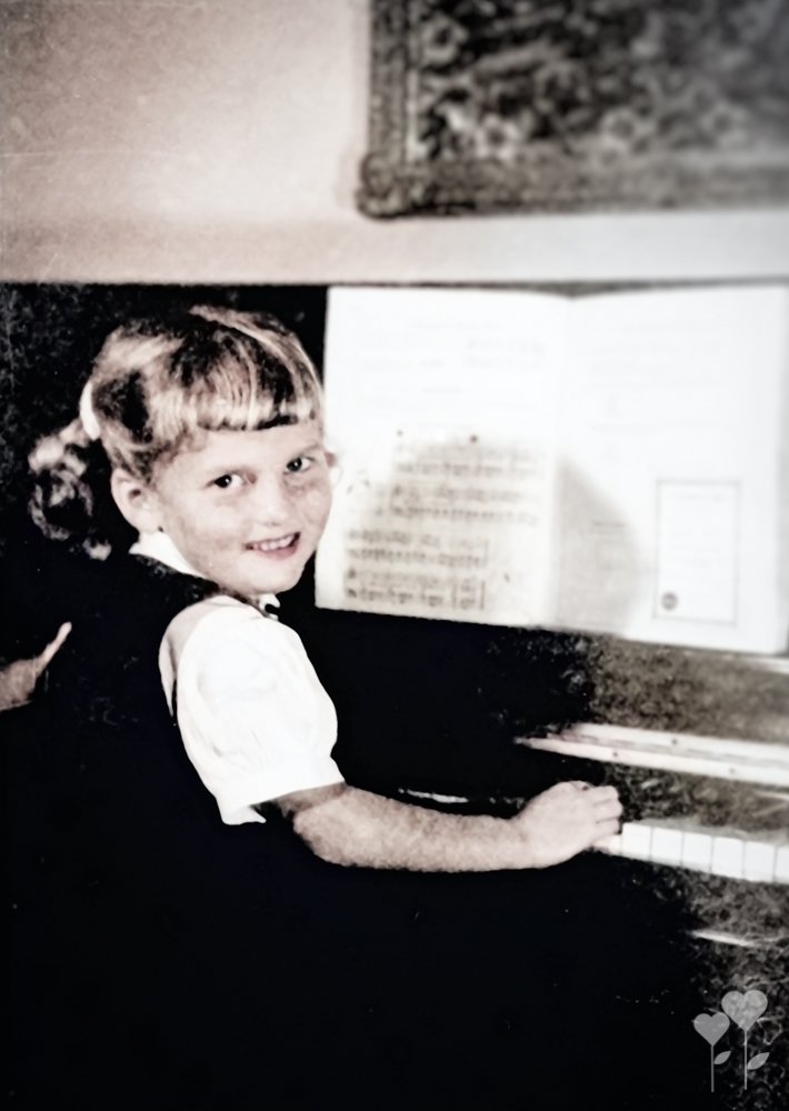 a little girl is playing a piano in a black and white photo