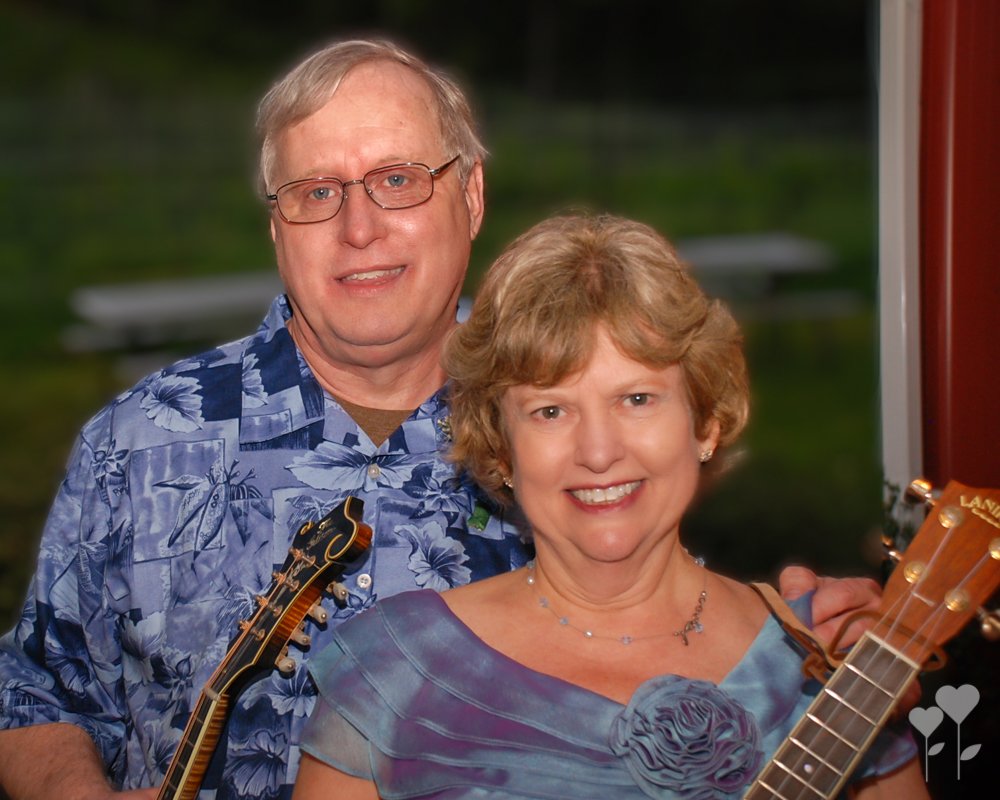 a man and woman are posing for a picture and the man is wearing a shirt that says hawaiian