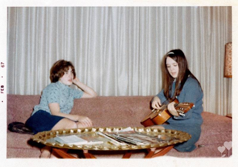 two girls sitting on a couch one playing a guitar and the date february 67