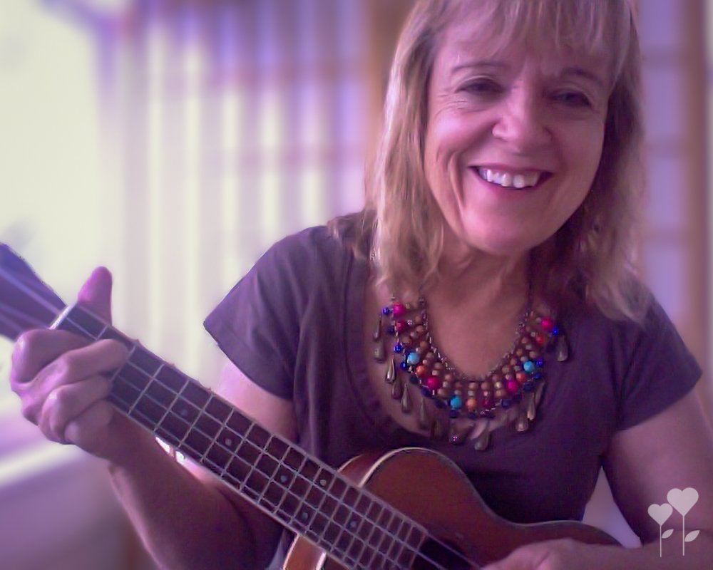 a woman is smiling while playing an ukulele