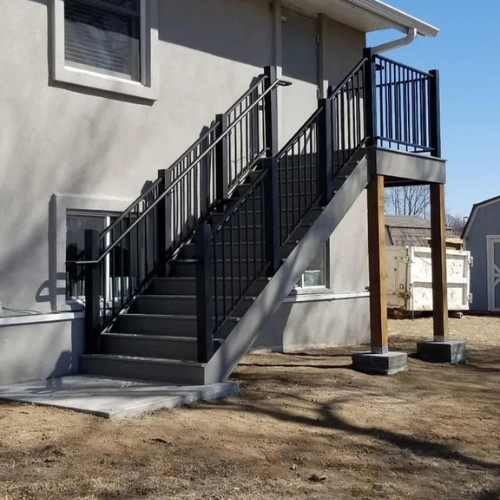 a black powdercoated custom metal stair railing and landing fabricated and installed by 83MetalCraft, LLC