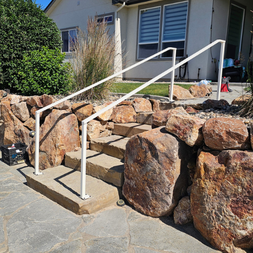 A white handrail fabricated and installed by 83MetalCraft, LLC