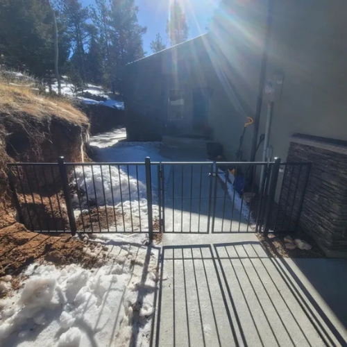 A custom iron gate and fence fabricated by 83MetalCraft for a home in McCall Idaho.