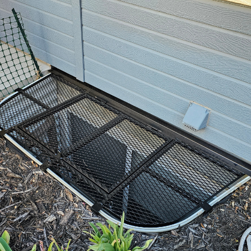 A black window well cover fabricated by 83MetalCraft, LLC