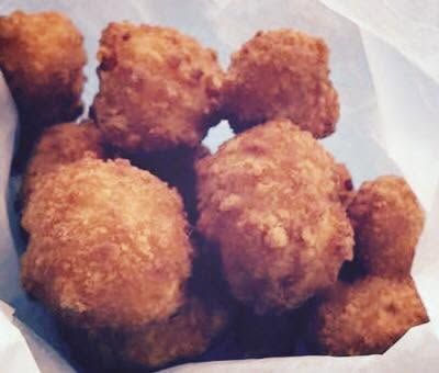 Plate of golden-brown fried nuggets on white paper