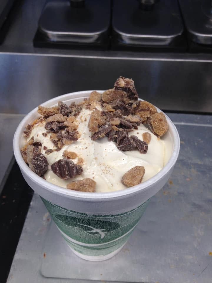 Cup of vanilla ice cream topped with chocolate cookie crumbles on a counter