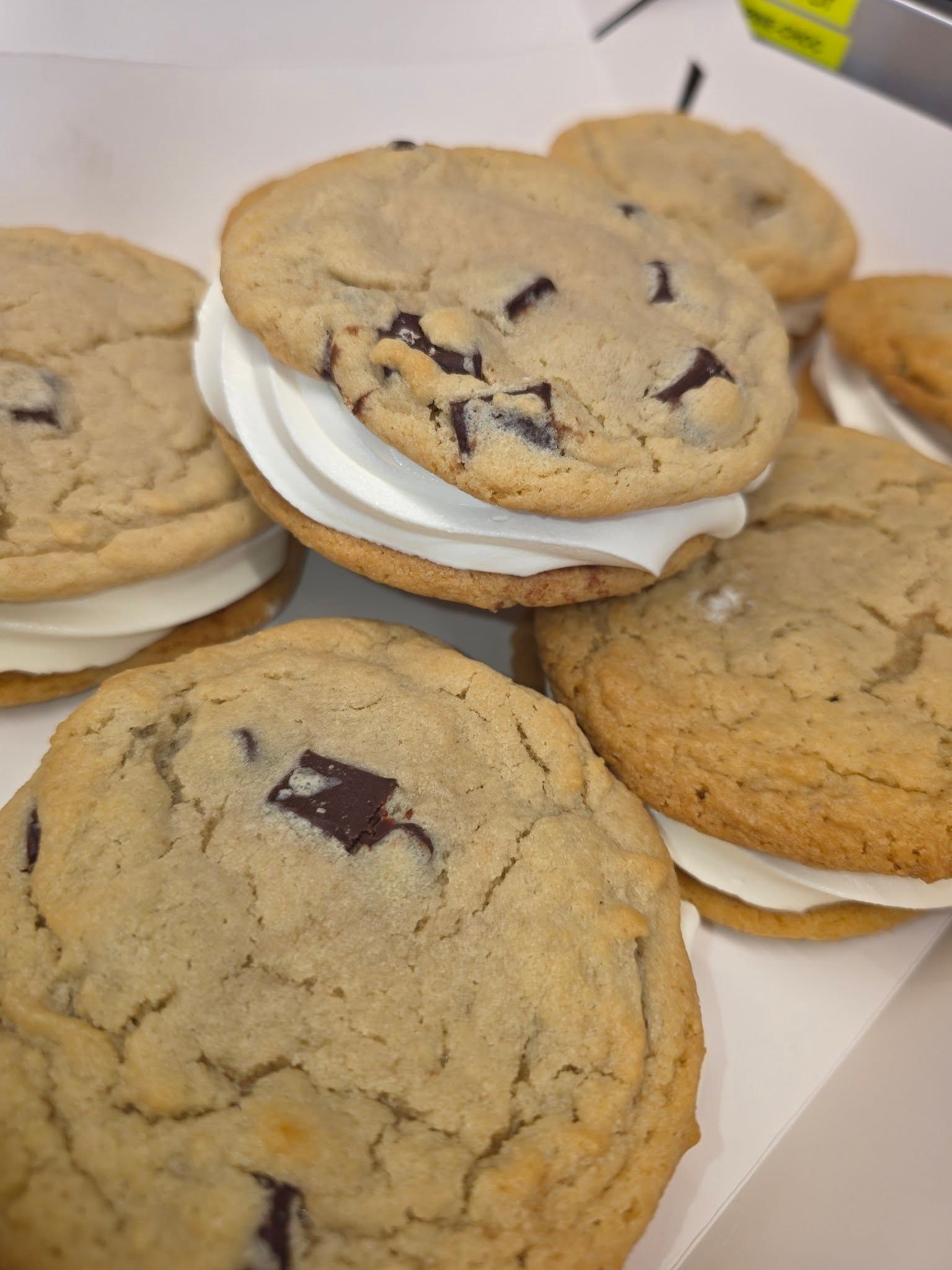 Plate of chocolate chip cookies, some stacked on a white napkin, close-up view