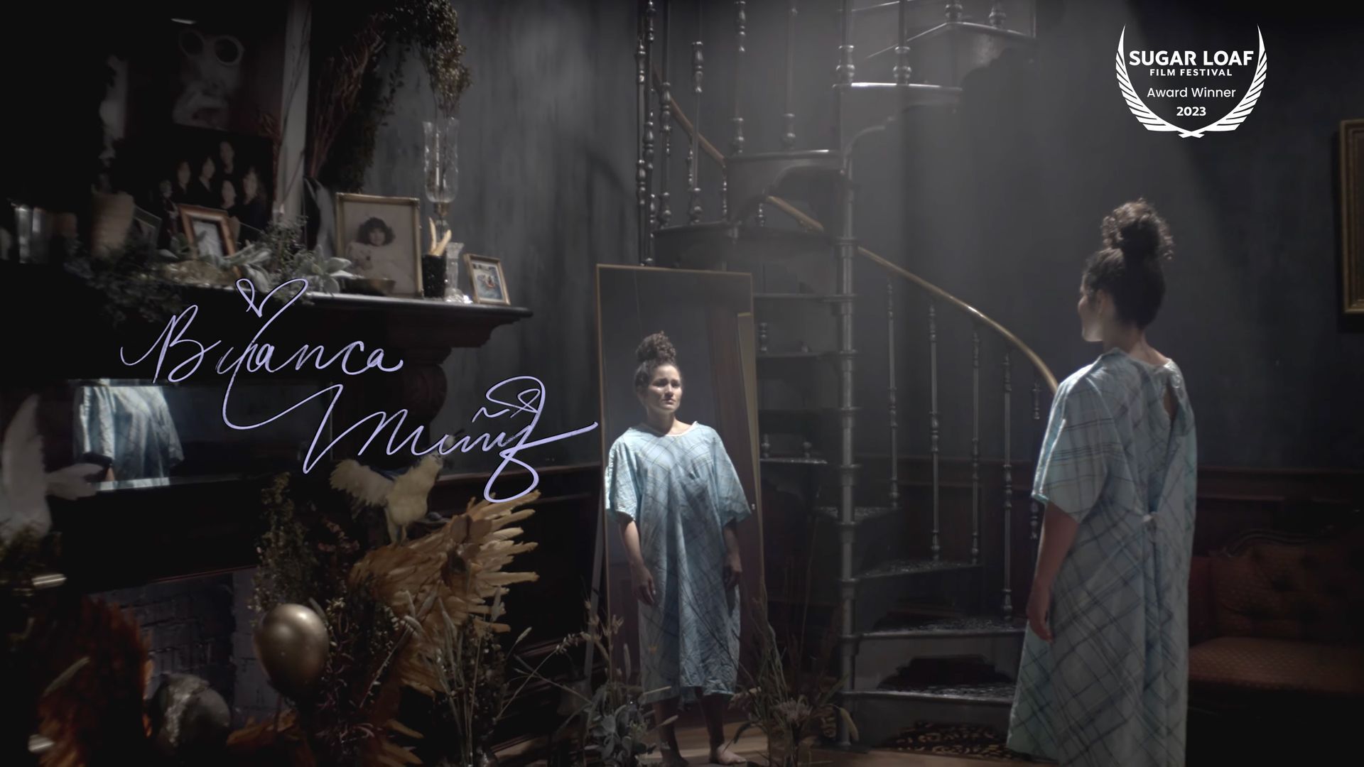 Woman standing in spotlit mansion in hospital gown