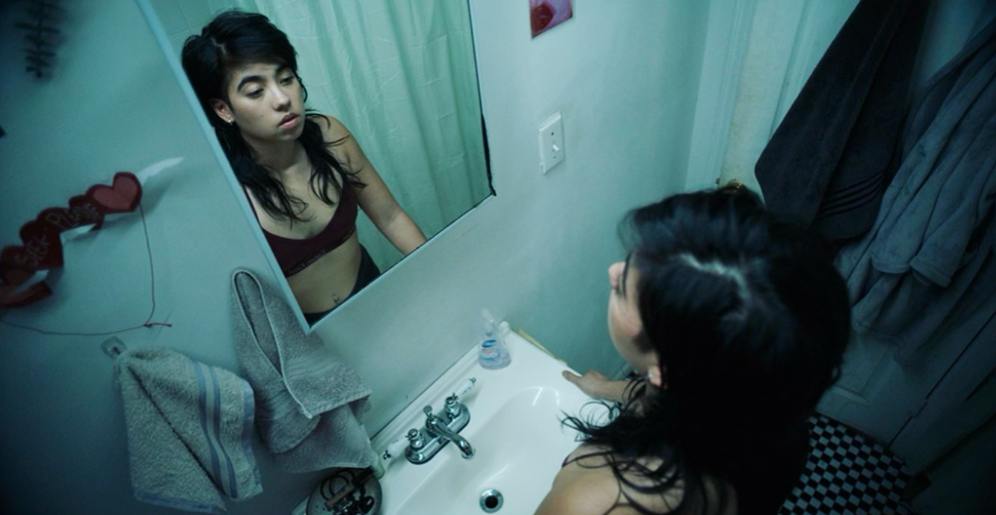 Woman staring in bathroom mirror