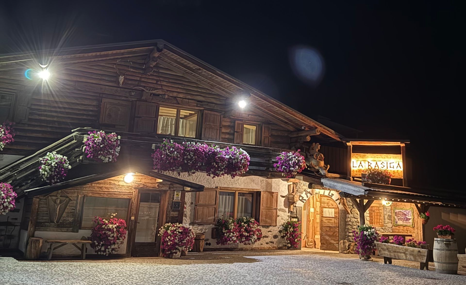 Un ristorante con tavoli e sedie in legno e un muro in pietra