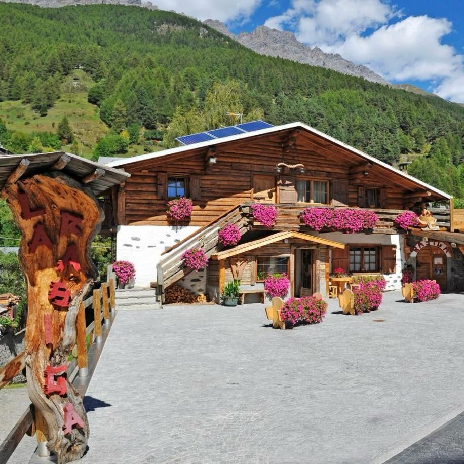 Una baita di tronchi è illuminata di notte con un cartello sulla facciata.