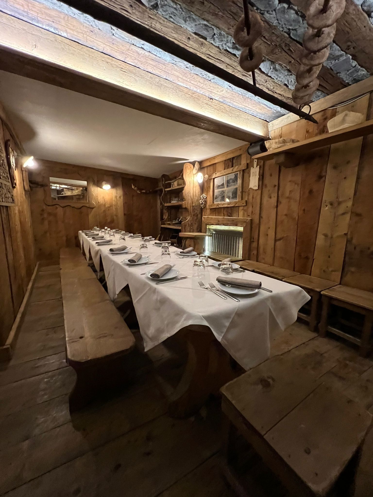Una casa di legno con fiori rosa davanti.