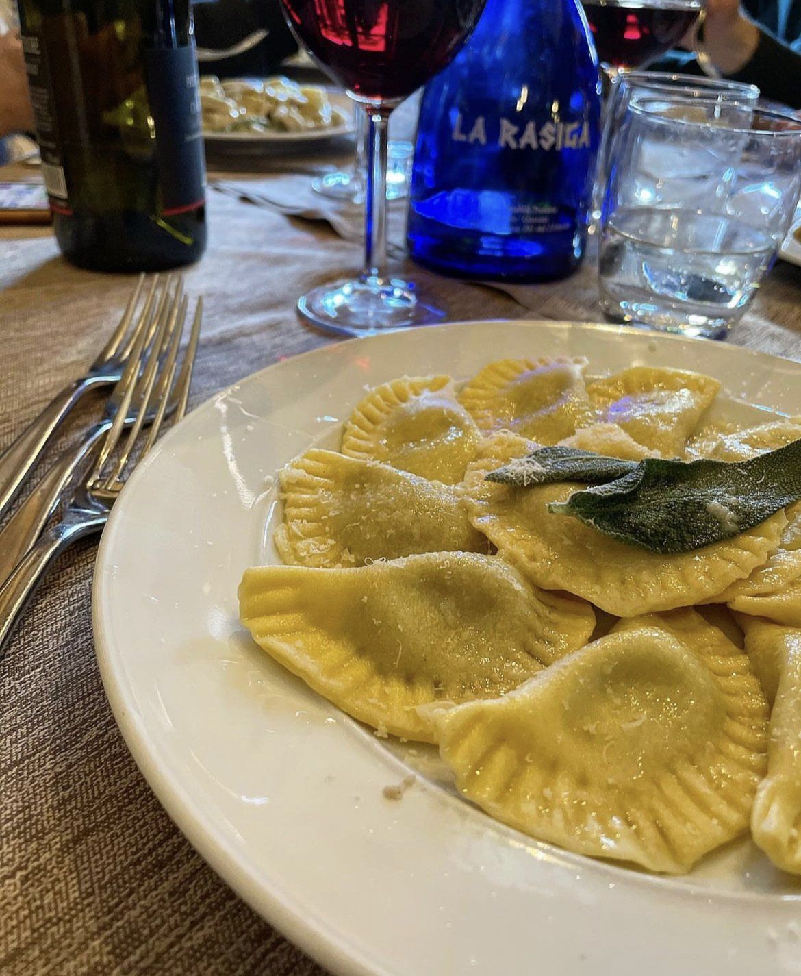 Primo piano di un piatto di ravioli alla salvia su un tavolo.