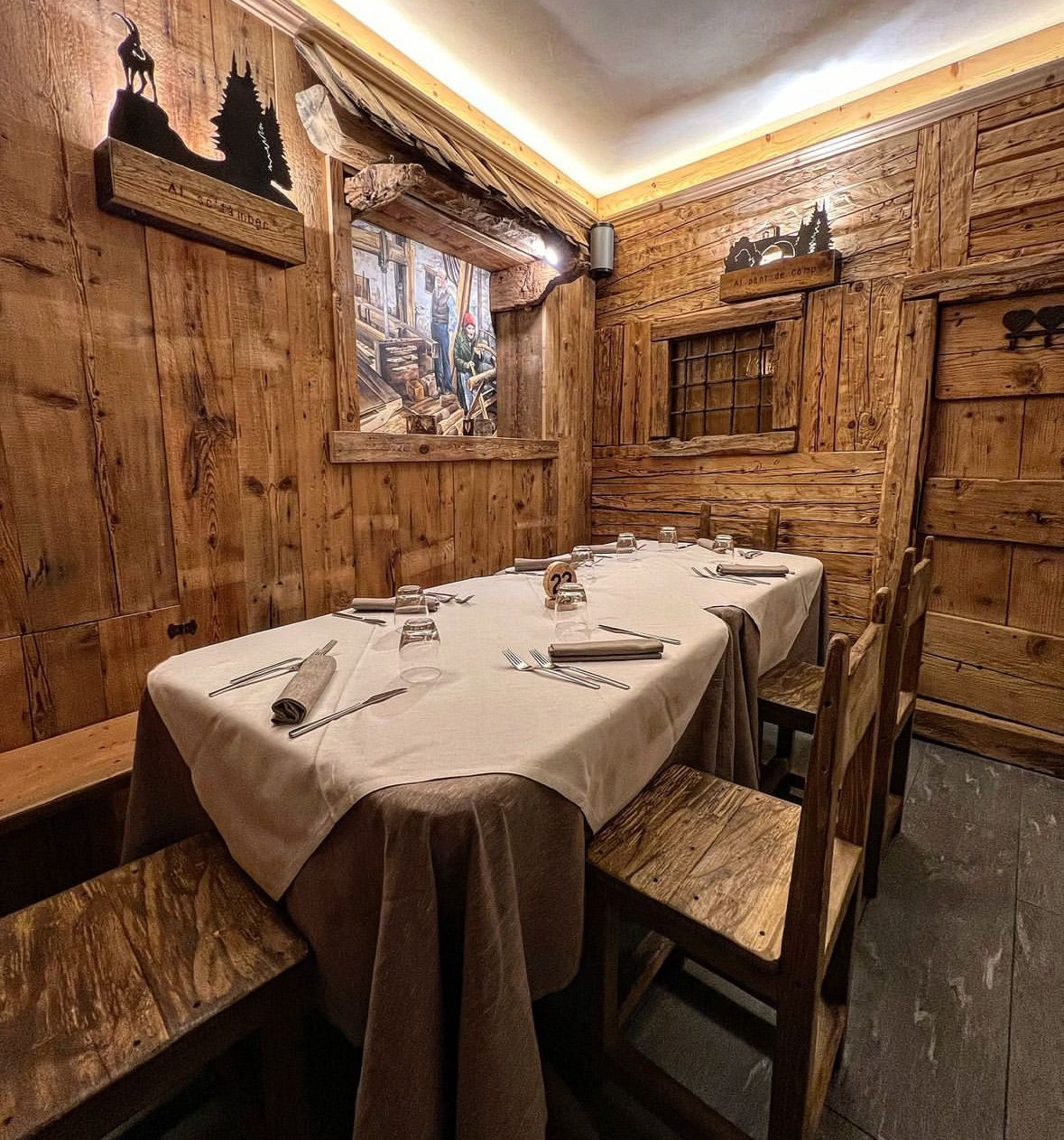Una casa di legno con fiori rosa davanti.