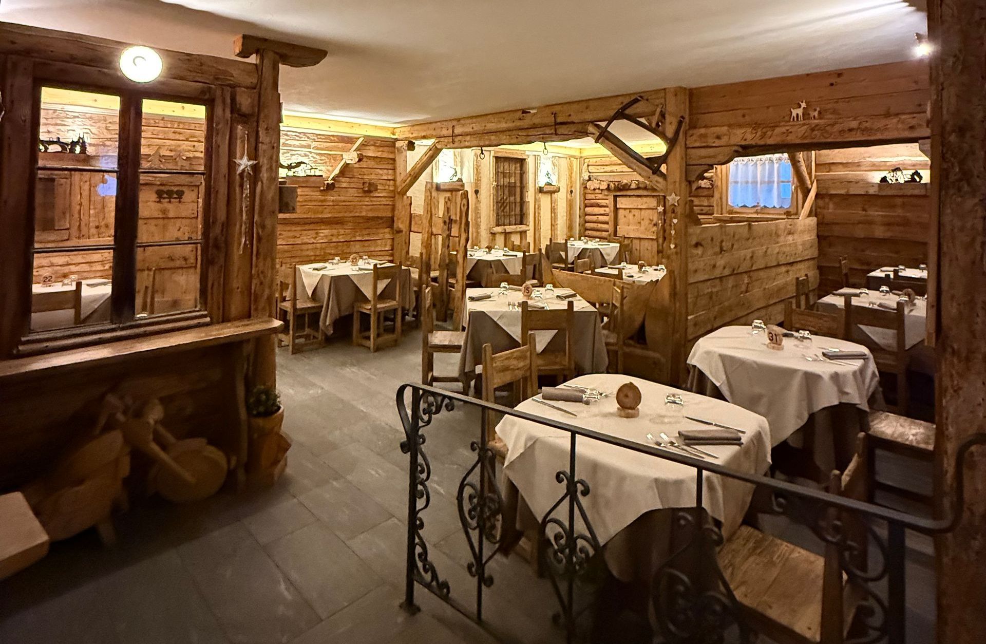 Un ristorante con tavoli e sedie in legno e una finestra