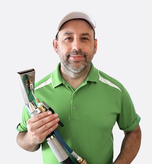 Man in a green polo and cap holding a vacuum cleaner against a white background