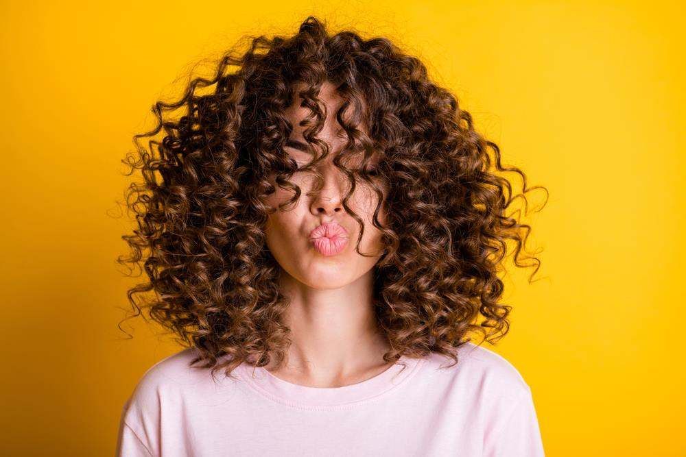 Curly-Haired Person with Hair Covering Their Face — Fraser Shores Hair Design in Urraween, QLD