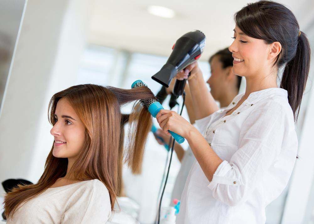 Stylist Blow-Drying a Client’s Hair in A Bright Salon — Fraser Shores Hair Design In Urraween, QLD