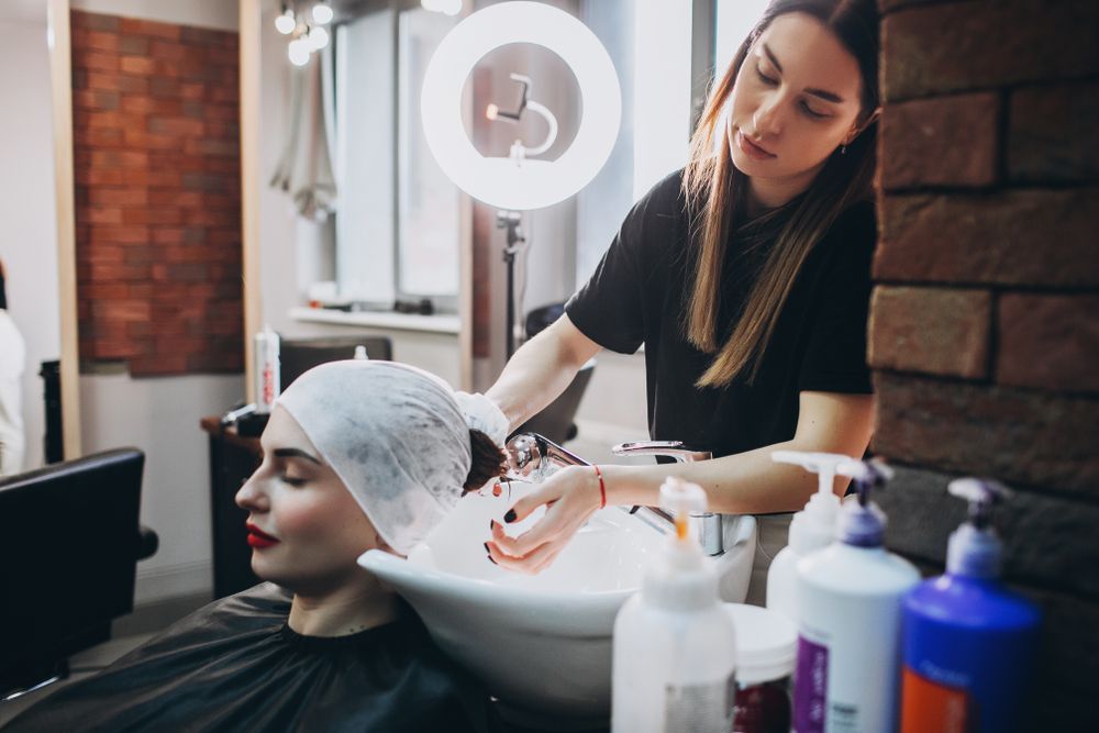 Person Receiving a Scalp Treatment While a Stylist Applies Product in a Salon — Fraser Shores Hair Design In Urraween, QLD