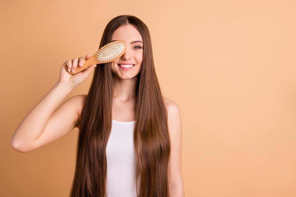 Woman Brushing Long Hair with A Hairbrush — Fraser Shores Hair Design In Urraween, QLD