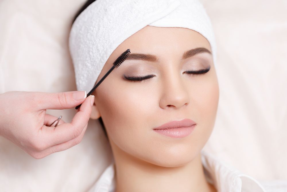 A Woman is Getting Her Eyebrows Done at a Beauty Salon — Fraser Shores Hair Design in Fraser Coast, QLD