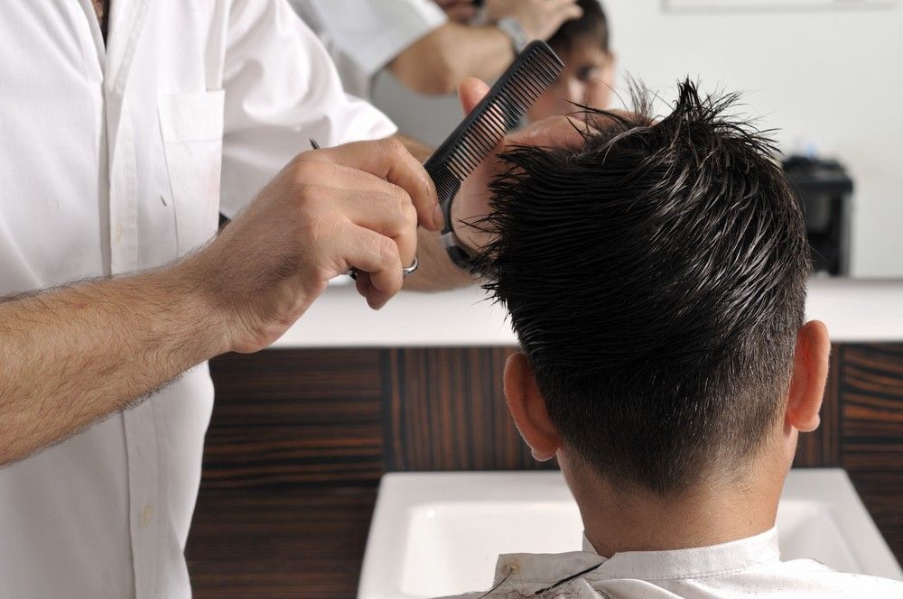 A Man is Getting His Hair Combed by a Barber — Fraser Shores Hair Design In Urraween, QLD