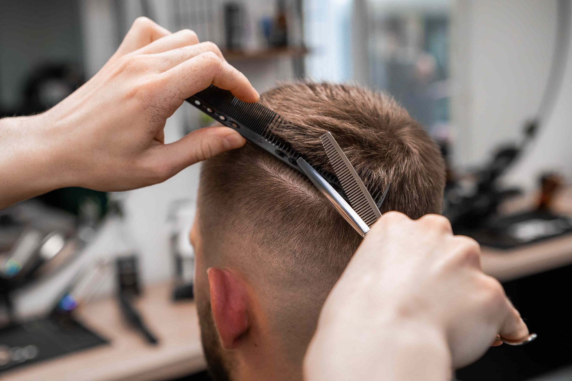 Hairdresser Cutting a Client’s Short Brown Hair With Scissors and Comb — Fraser Shores Hair Design in Urraween, QLD