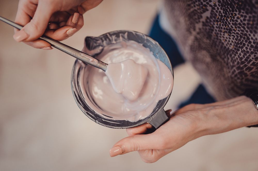 Hands Mixing Pink Hair Dye in a Bowl With a Brush — Fraser Shores Hair Design In Urraween, QLD