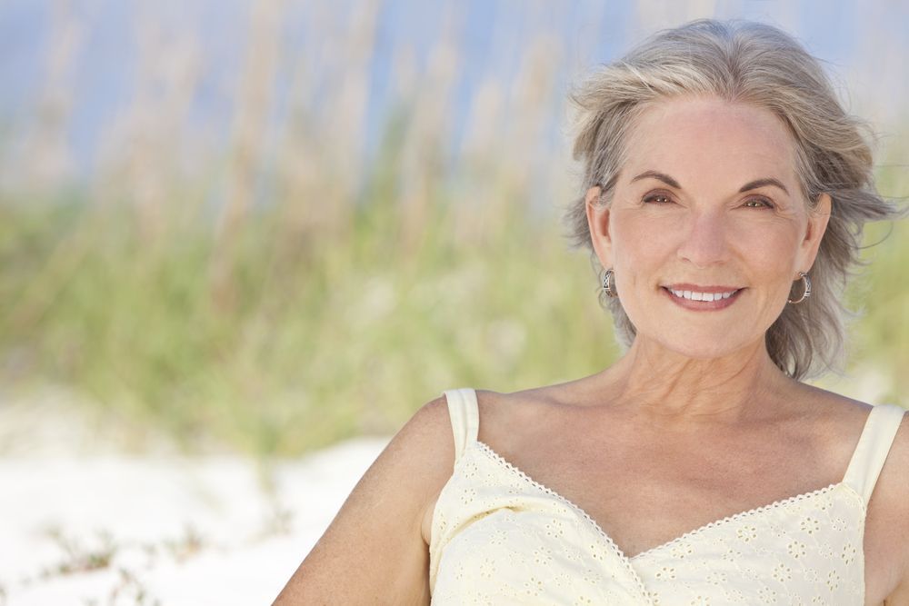 Smiling Woman in a White Dress — Fraser Shores Hair Design In Urraween, QLD