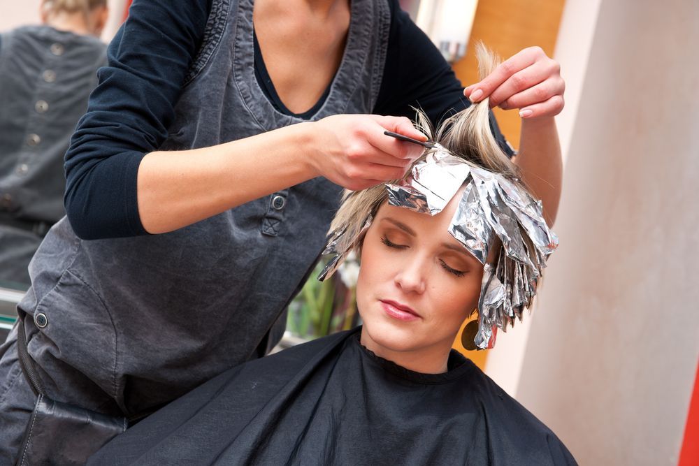 Stylist Applying Foil Highlights to a Client’s Hair in a Salon Chair — Fraser Shores Hair Design In Urraween, QLD