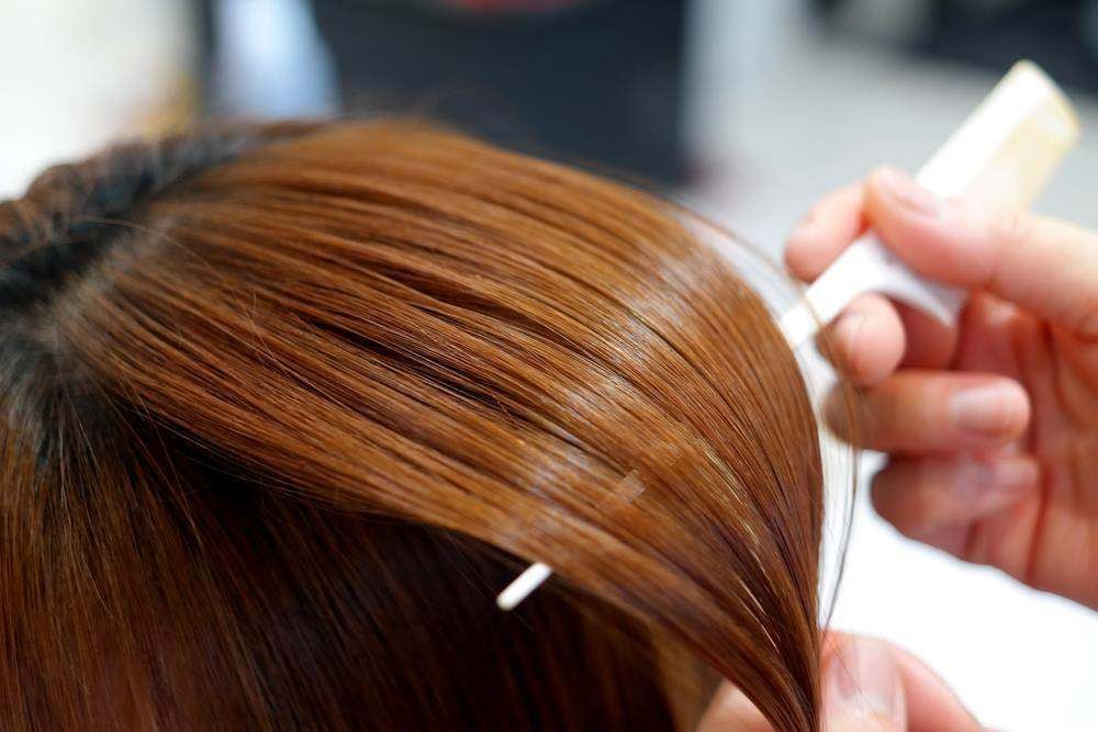 Hair Dye Being Applied to Brown Hair with A Brush and Clip in A Salon — Fraser Shores Hair Design In Urraween, QLD