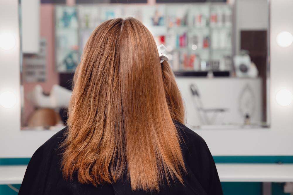 Person with Long Light-Brown Hair Seen from Behind in A Salon Chair — Fraser Shores Hair Design In Urraween, QLD
