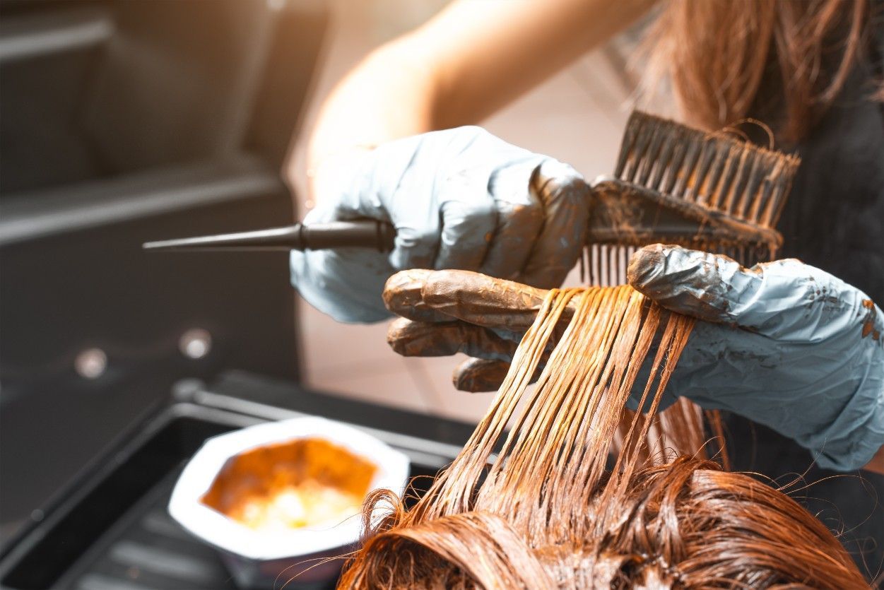 A Woman is Getting Her Hair Dyed in a Salon — Fraser Shores Hair Design In Urraween, QLD