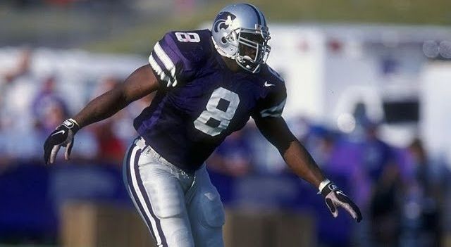 Football player on field in purple jersey and silver helmet and pants.