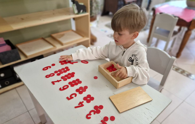 o fetita lucrand cu Materiale 3-6 ani Montessori Cluj la Gradinita Montessori Cluj
