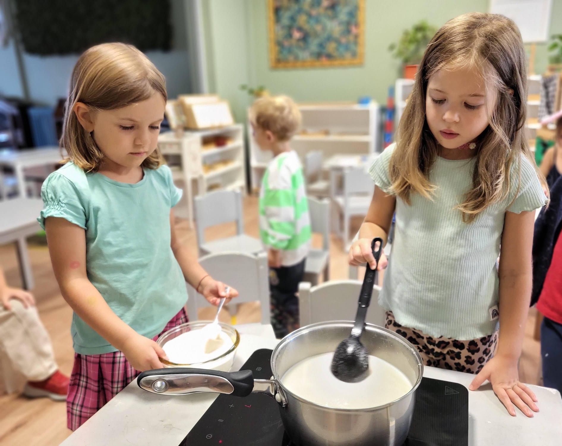 Two young girls are stirring a pot of liquid with a ladle.